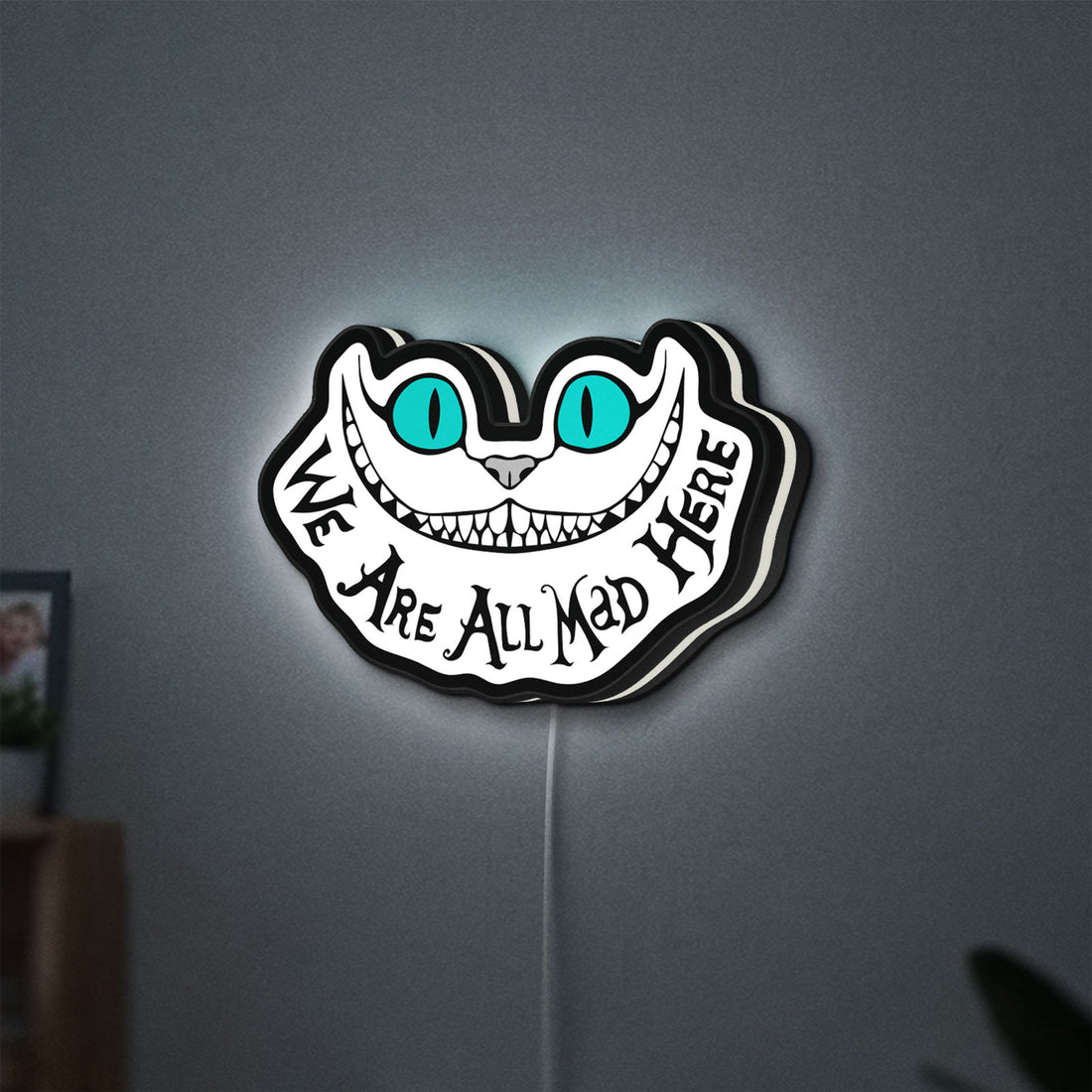 Alice in Wonderland Cheshire Cat LED lightbox hanging on a wall with white glow