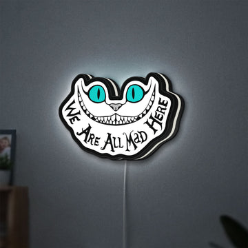 Alice in Wonderland Cheshire Cat LED lightbox hanging on a wall with white glow