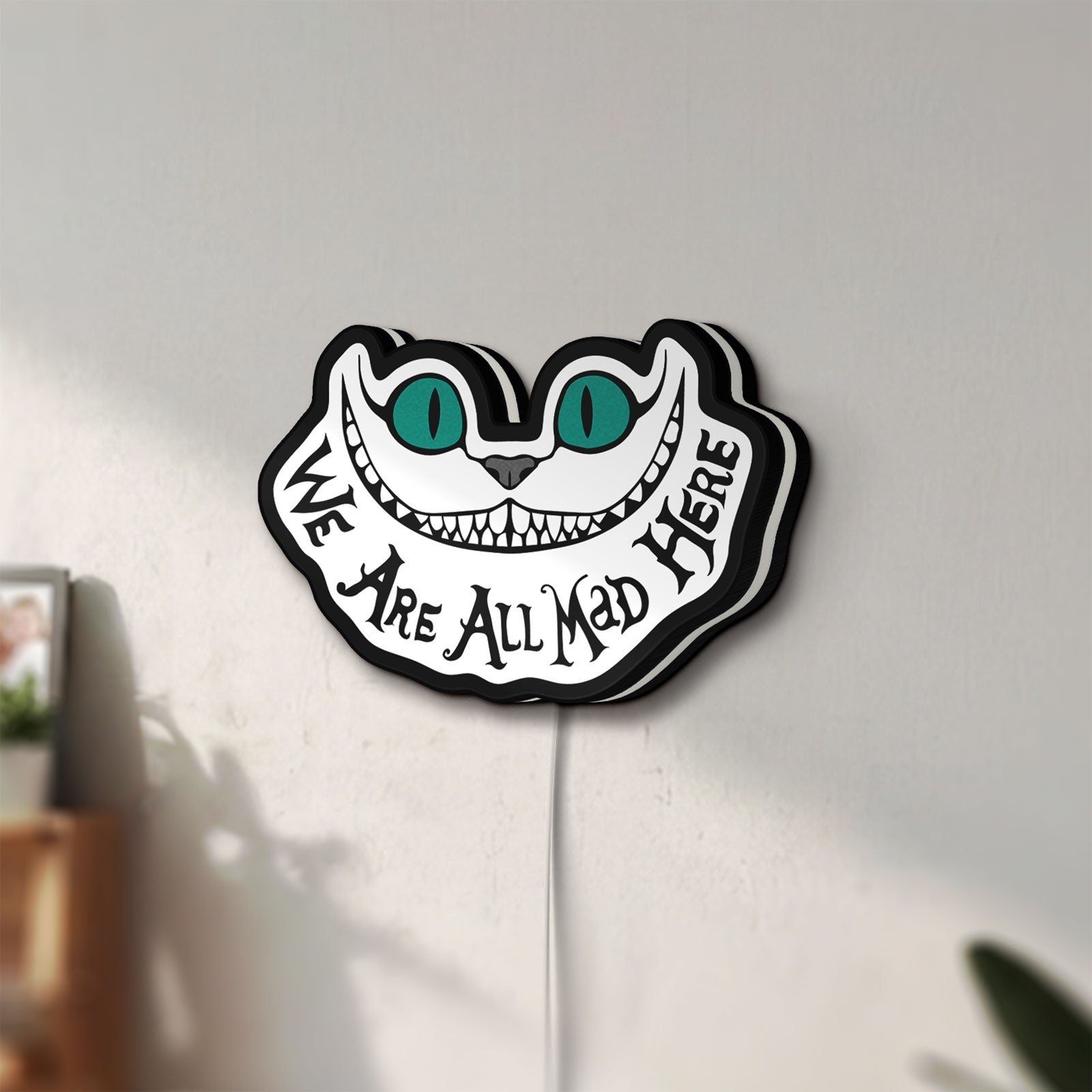 Unlit Alice in Wonderland Cheshire Cat LED lightbox mounted on a wall in daylight