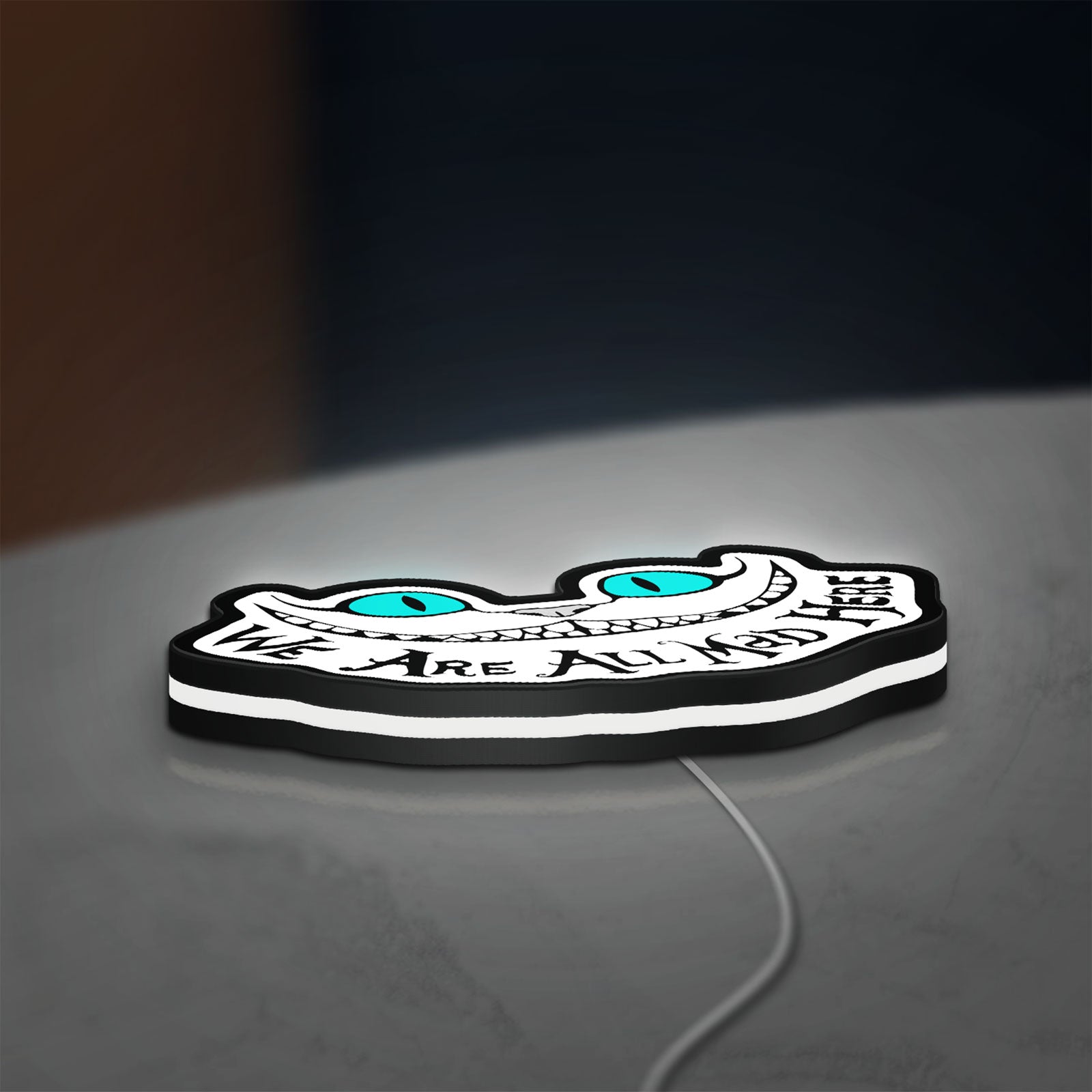 Alice in Wonderland Cheshire Cat LED lightbox lying flat on a desk with white glow