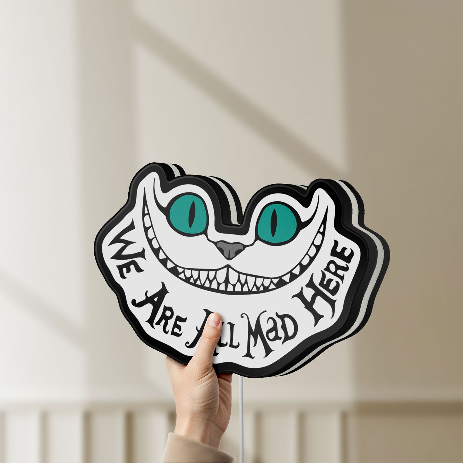 Unlit Alice in Wonderland Cheshire Cat LED lightbox held by hand to show size and details