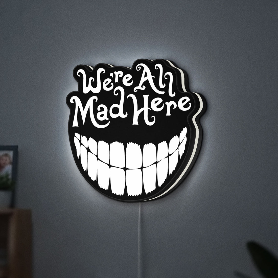 Alice in Wonderland Cheshire Cat LED lightbox hanging on a wall with white glow
