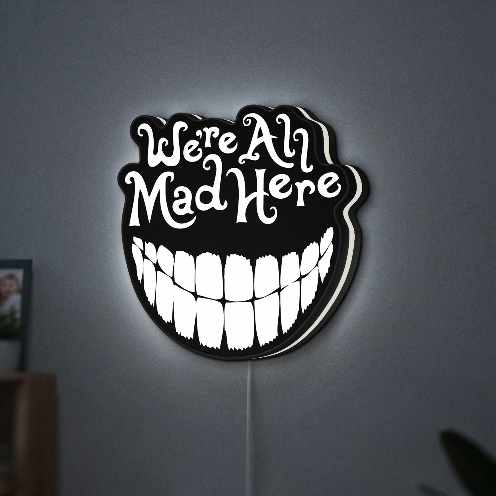 Alice in Wonderland Cheshire Cat LED lightbox hanging on a wall with white glow