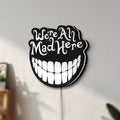 Unlit Alice in Wonderland Cheshire Cat LED lightbox mounted on a wall in daylight