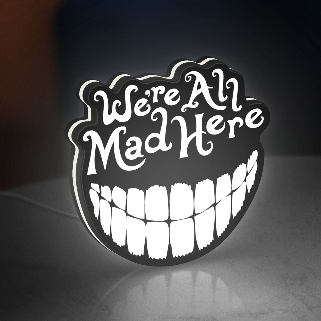 Alice in Wonderland Cheshire Cat LED lightbox hanging on a wall with white glow
