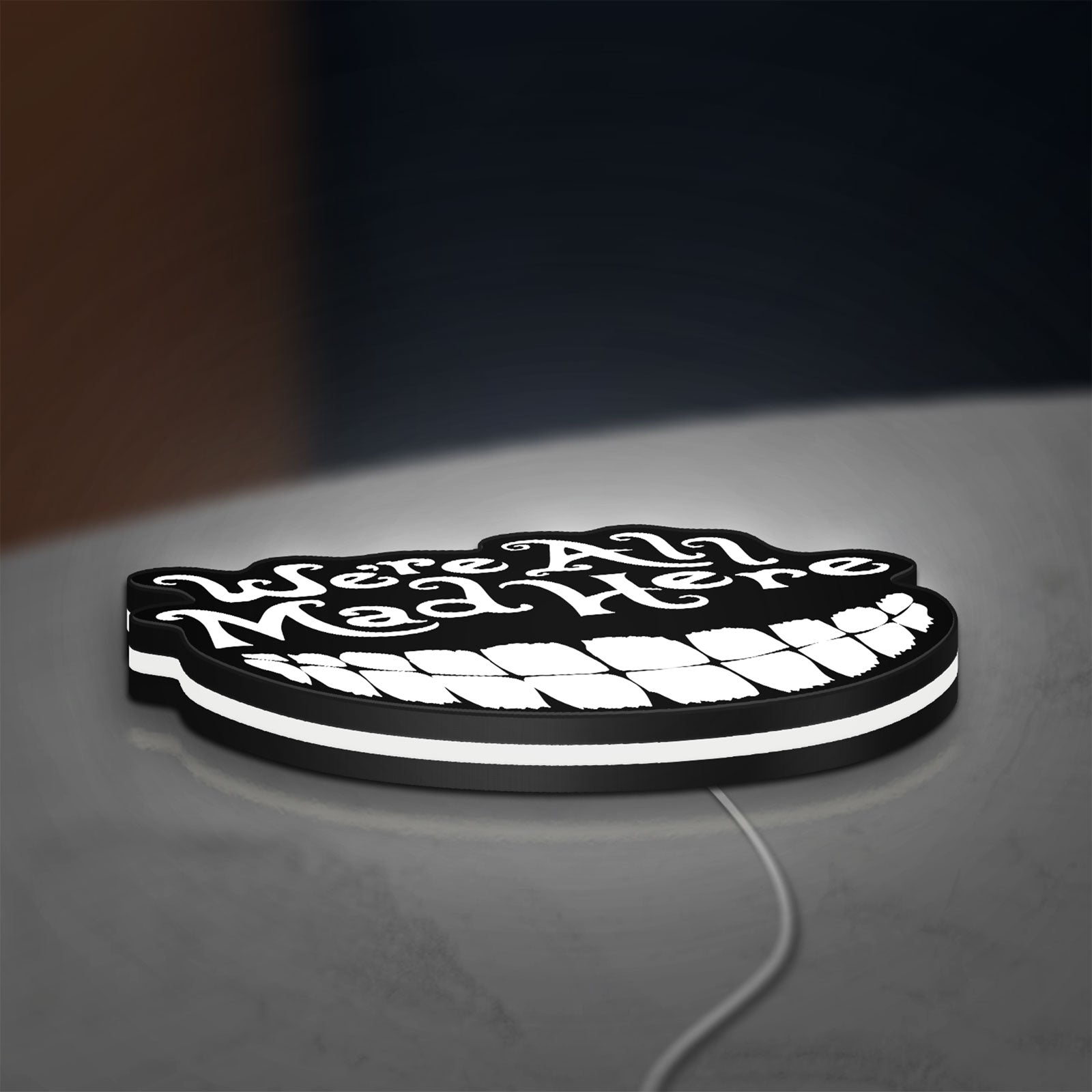 Alice in Wonderland Cheshire Cat LED lightbox lying flat on a desk with white glow