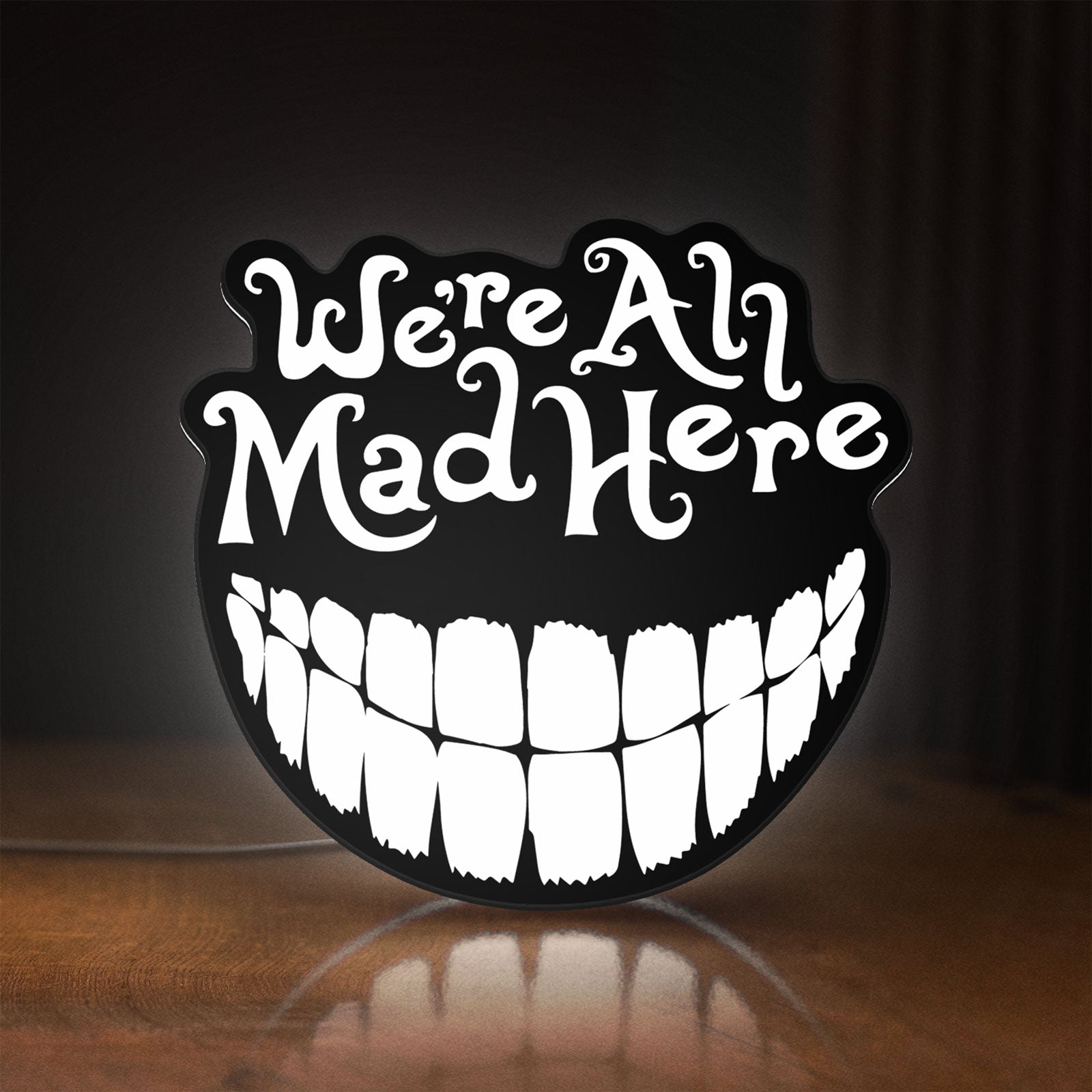 Front view of Alice in Wonderland Cheshire Cat LED lightbox sign glowing on a wooden desk