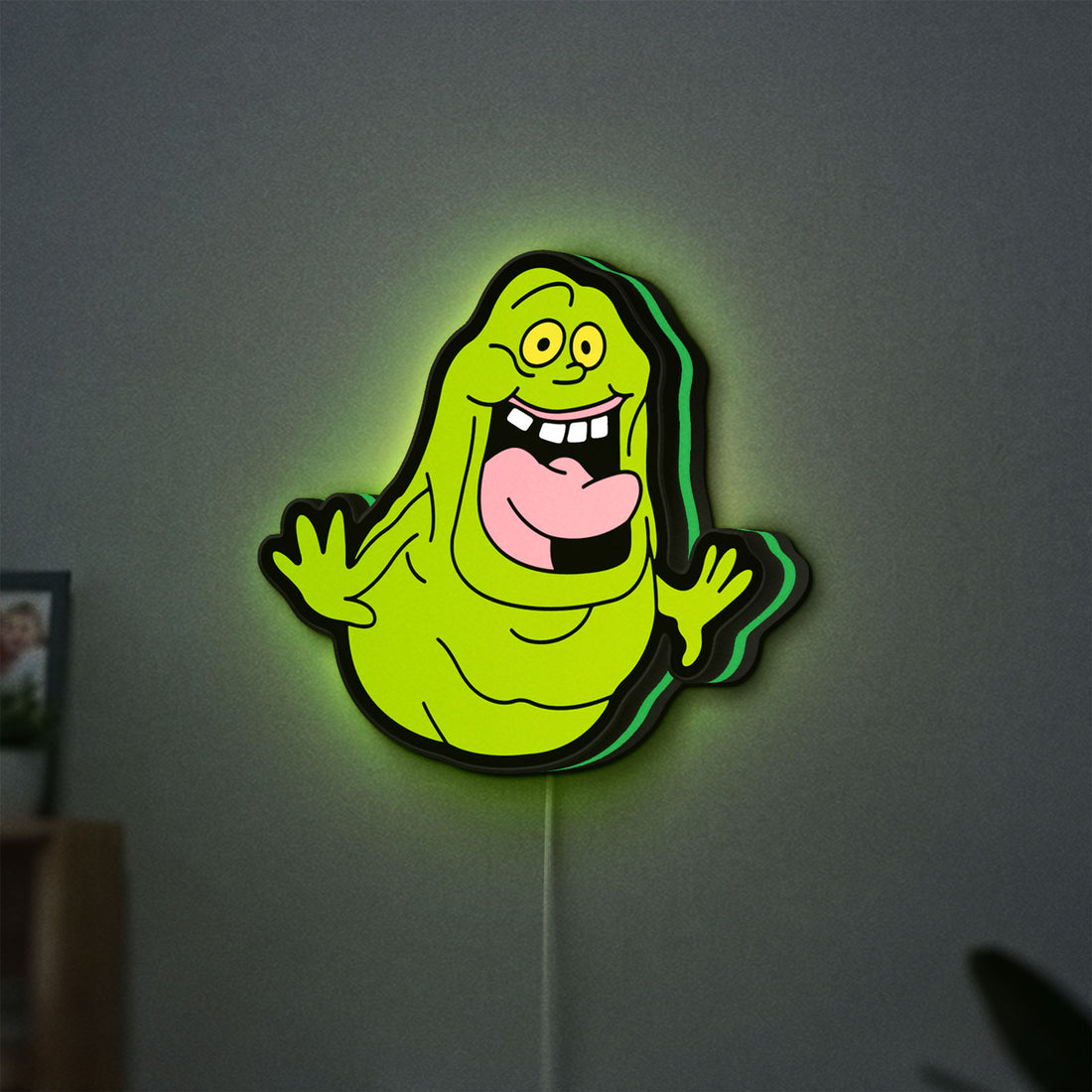 Ghostbusters Slimer 80s Movie LED lightbox hanging on a wall with green glow