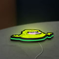 Ghostbusters Slimer 80s Movie LED lightbox lying flat on a desk with green glow