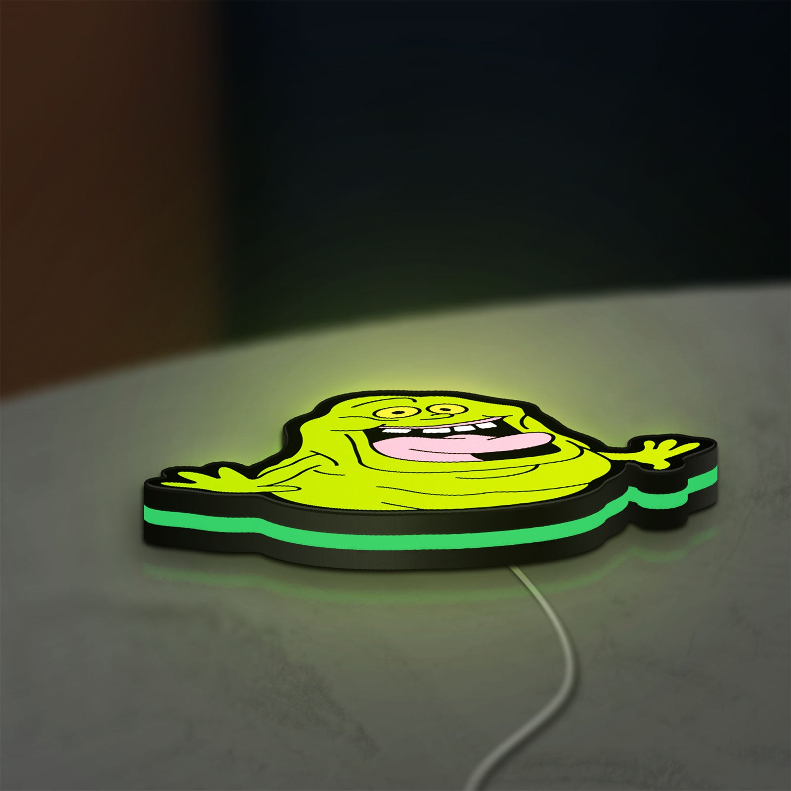 Ghostbusters Slimer 80s Movie LED lightbox lying flat on a desk with green glow