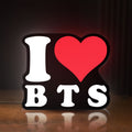 Front view of I love BT LED lightbox sign glowing on a wooden desk