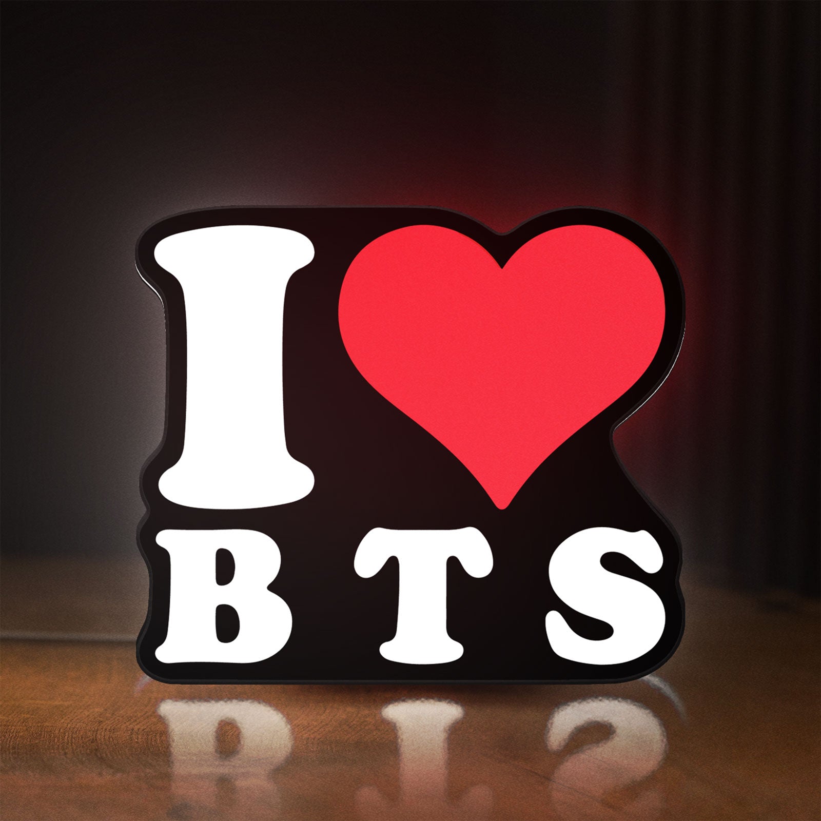 Front view of I love BT LED lightbox sign glowing on a wooden desk