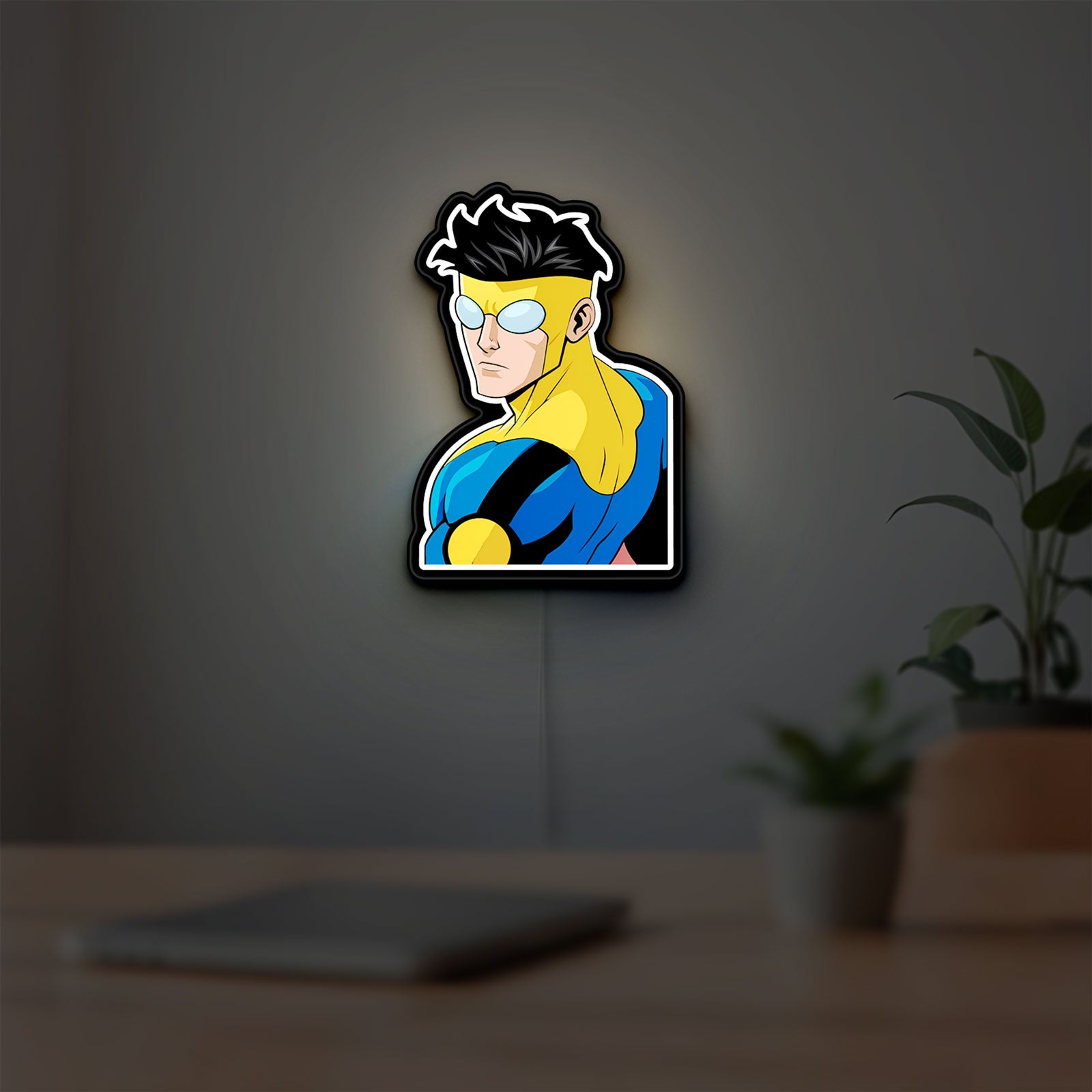 Invincible Title Logo Superhero LED lightbox hanging on a room wall with soft white light