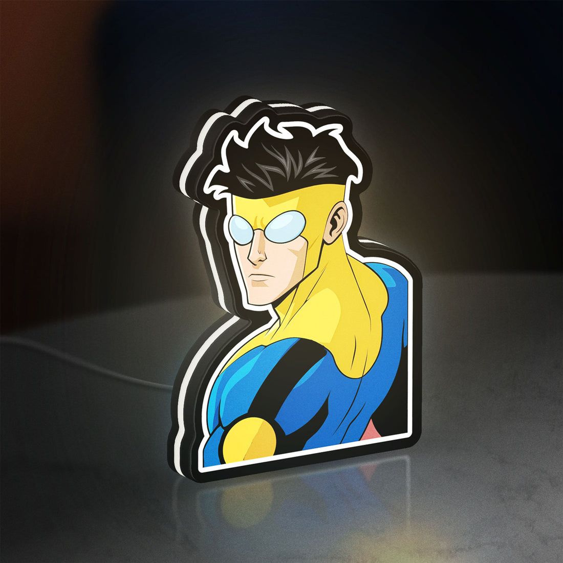 Invincible Title Logo Superhero LED lightbox hanging on a wall with white glow
