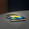 Invincible Title Logo Superhero LED lightbox lying flat on a desk with white glow