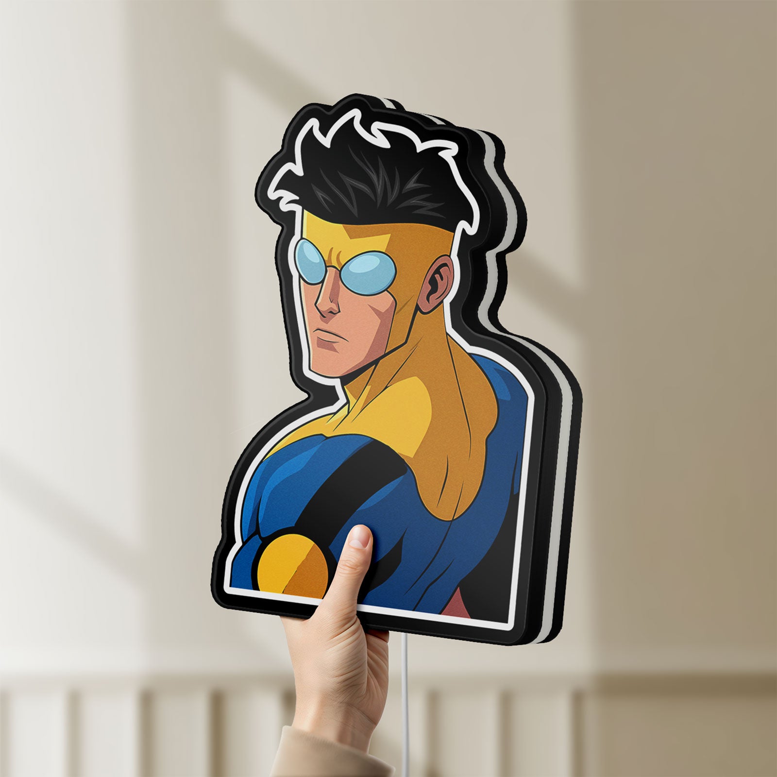 Unlit Invincible Title Logo Superhero LED lightbox held by hand to show size and details