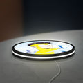 Invincible Title Logo Superhero LED lightbox lying flat on a desk with white glow