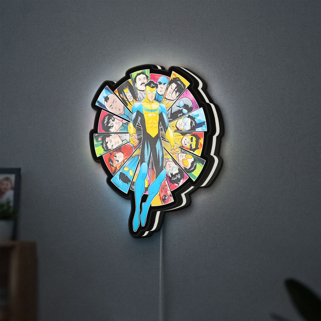 Invincible Title Logo Superhero LED lightbox hanging on a wall with white glow