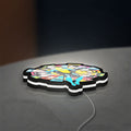 Invincible Title Logo Superhero LED lightbox lying flat on a desk with white glow