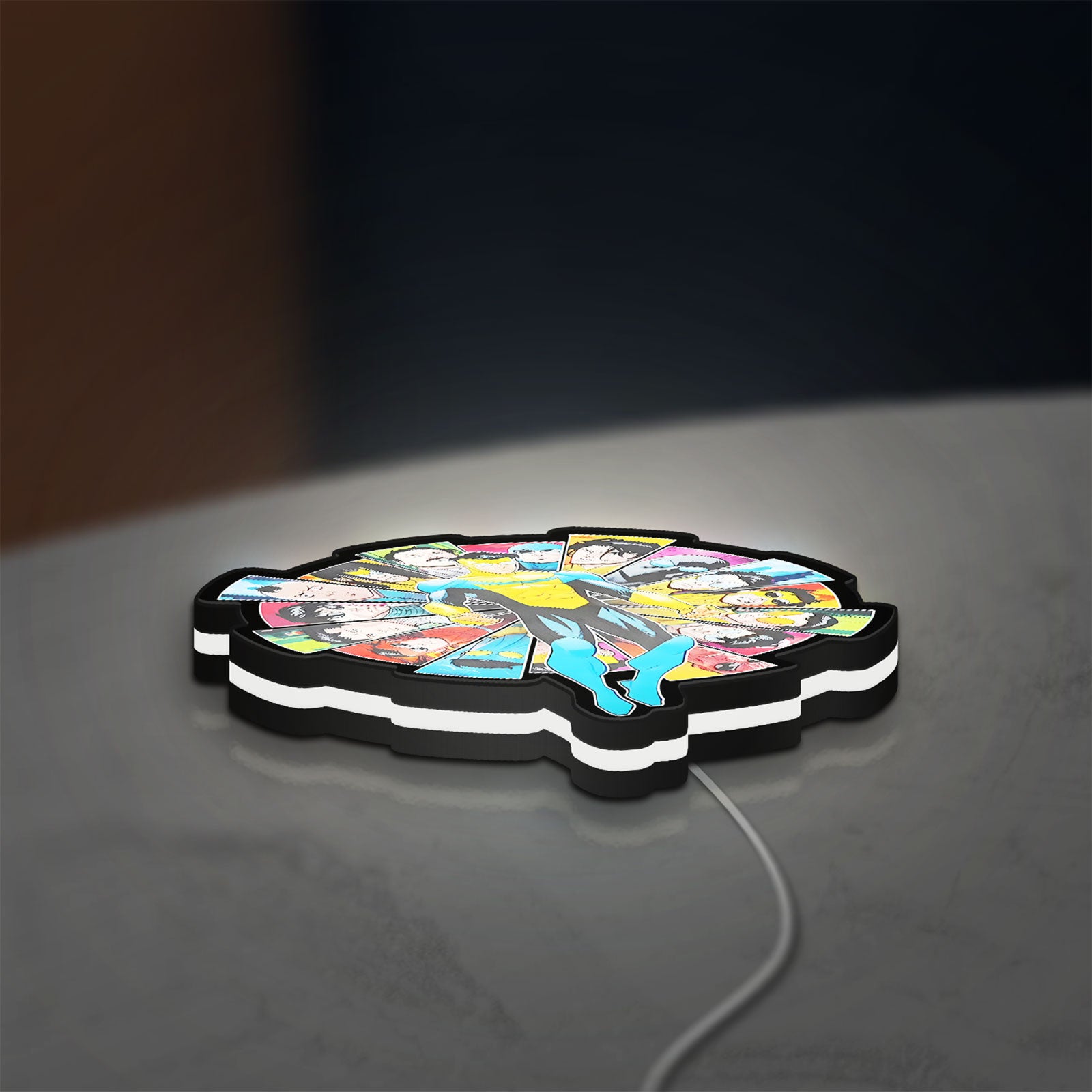 Invincible Title Logo Superhero LED lightbox lying flat on a desk with white glow