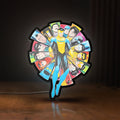 Front view of Invincible Title Logo Superhero LED lightbox sign glowing on a wooden desk