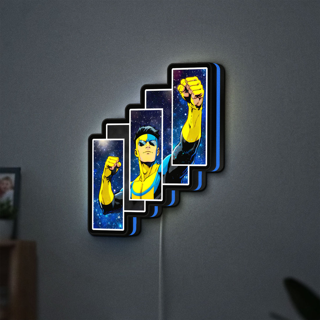 Invincible Title Logo Superhero LED lightbox hanging on a wall with blue glow
