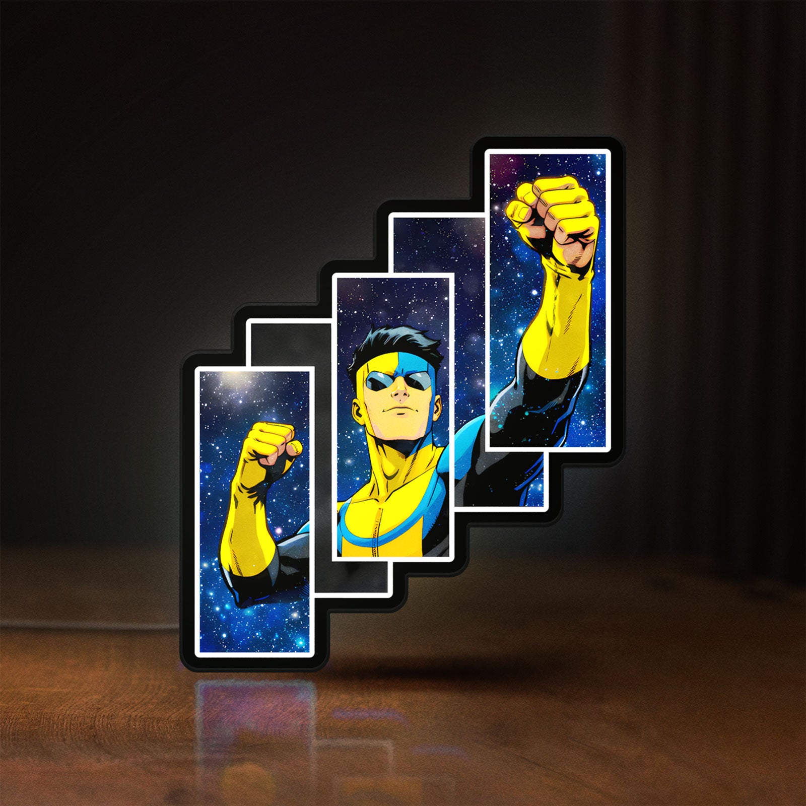 Front view of Invincible Title Logo Superhero LED lightbox sign glowing on a wooden desk