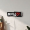 Unlit Invincible V Logo Mark Grayson LED lightbox mounted on a wall in daylight