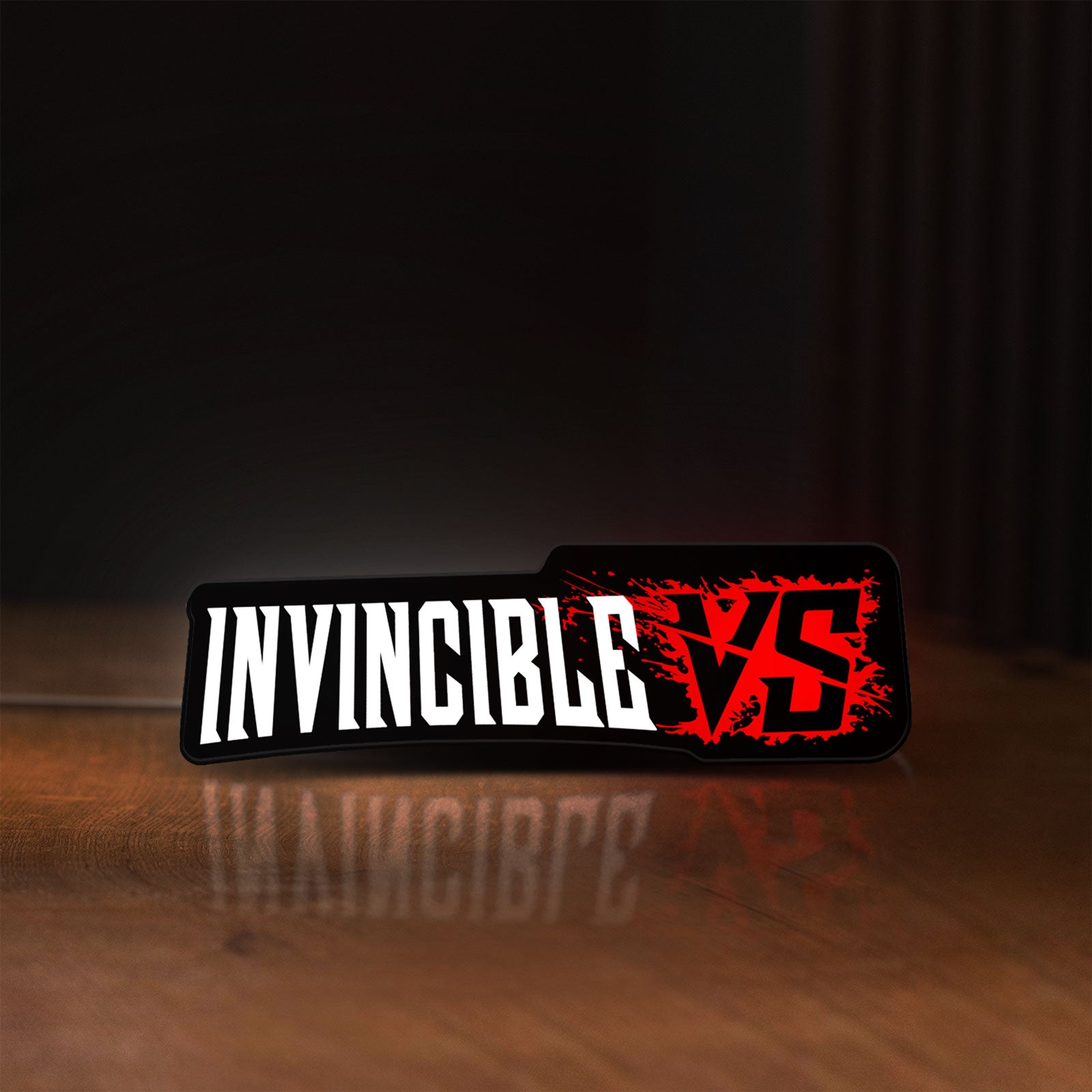 Front view of Invincible V Logo Mark Grayson LED lightbox sign glowing on a wooden desk