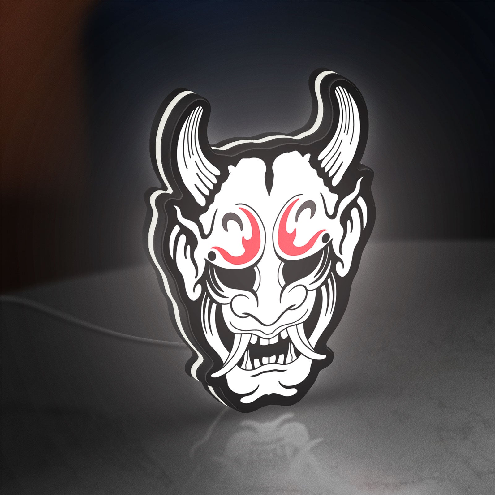 Cyberpunk Japanese Oni Mask Demon LED lightbox standing on a desk from an angled side view with white glow