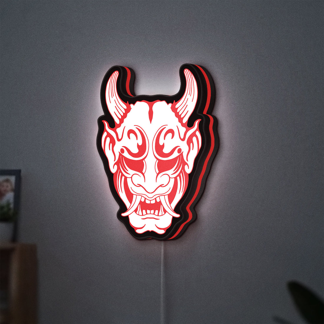Cyberpunk Japanese Oni Mask Demon LED lightbox hanging on a wall with red glow