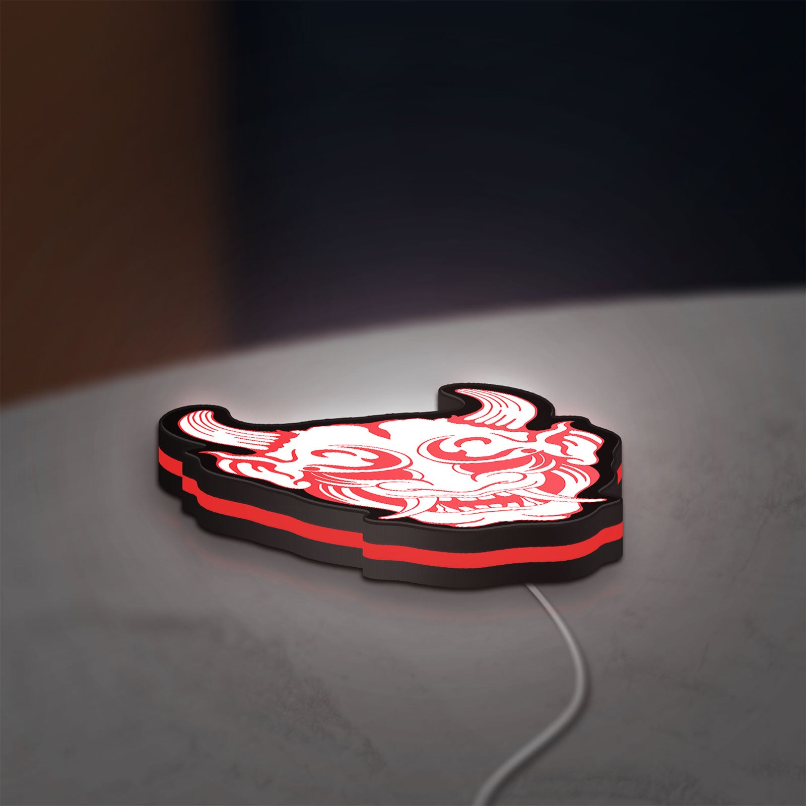 Cyberpunk Japanese Oni Mask Demon LED lightbox lying flat on a desk with red glow