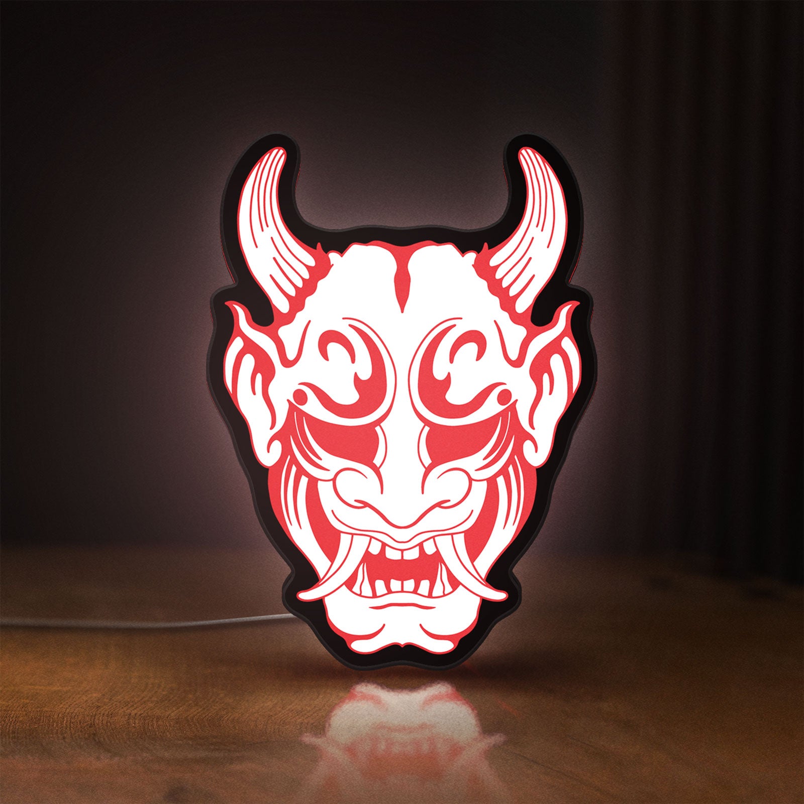 Front view of Cyberpunk Japanese Oni Mask Demon LED lightbox sign glowing on a wooden desk