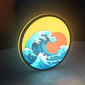 Great Wave off Kanagawa Ocean Art LED lightbox standing on a desk from an angled side view with yellow glow