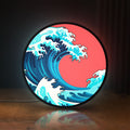 Front view of Great Wave off Kanagawa Ocean Art LED lightbox sign glowing on a wooden desk