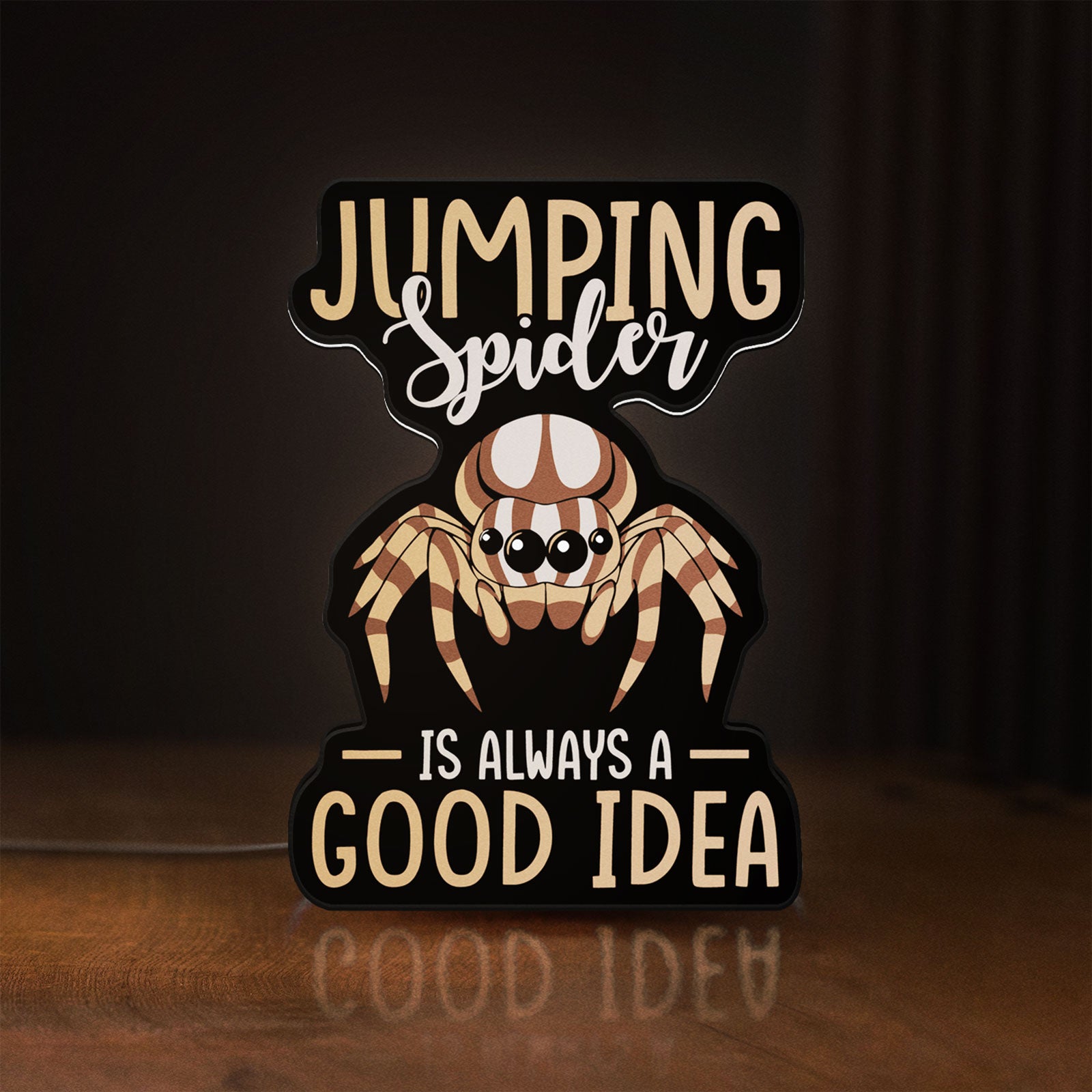 Front view of Cute Jumping Spider Arachnid Pet LED lightbox sign glowing on a wooden desk