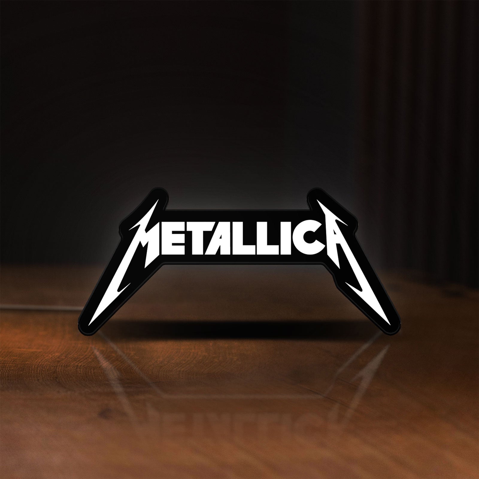 Front view of Metallica Band Logo Heavy Metal LED lightbox sign glowing on a wooden desk