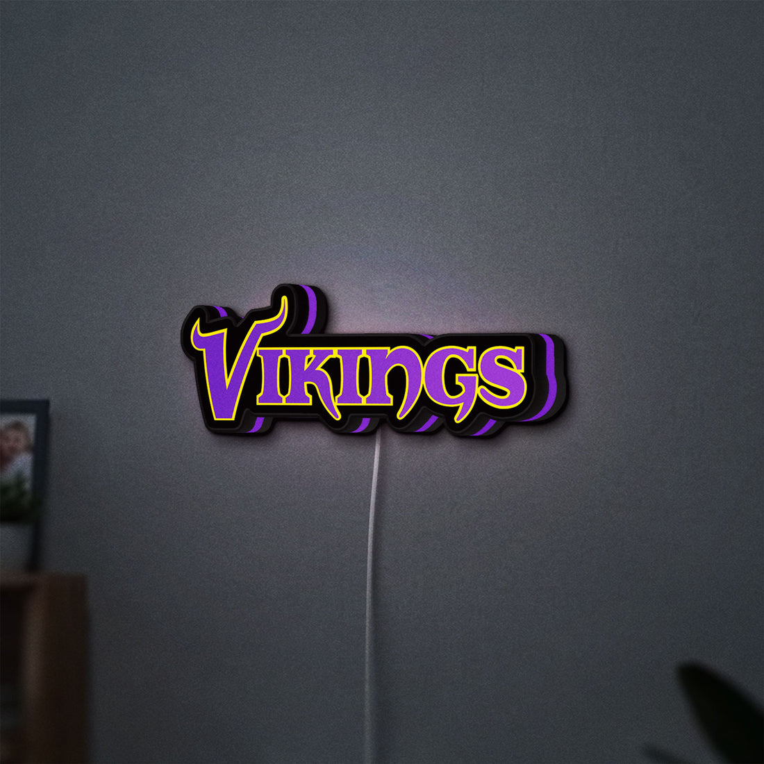 Minnesota Vikings NFL Pro Football LED lightbox hanging on a wall with purple glow