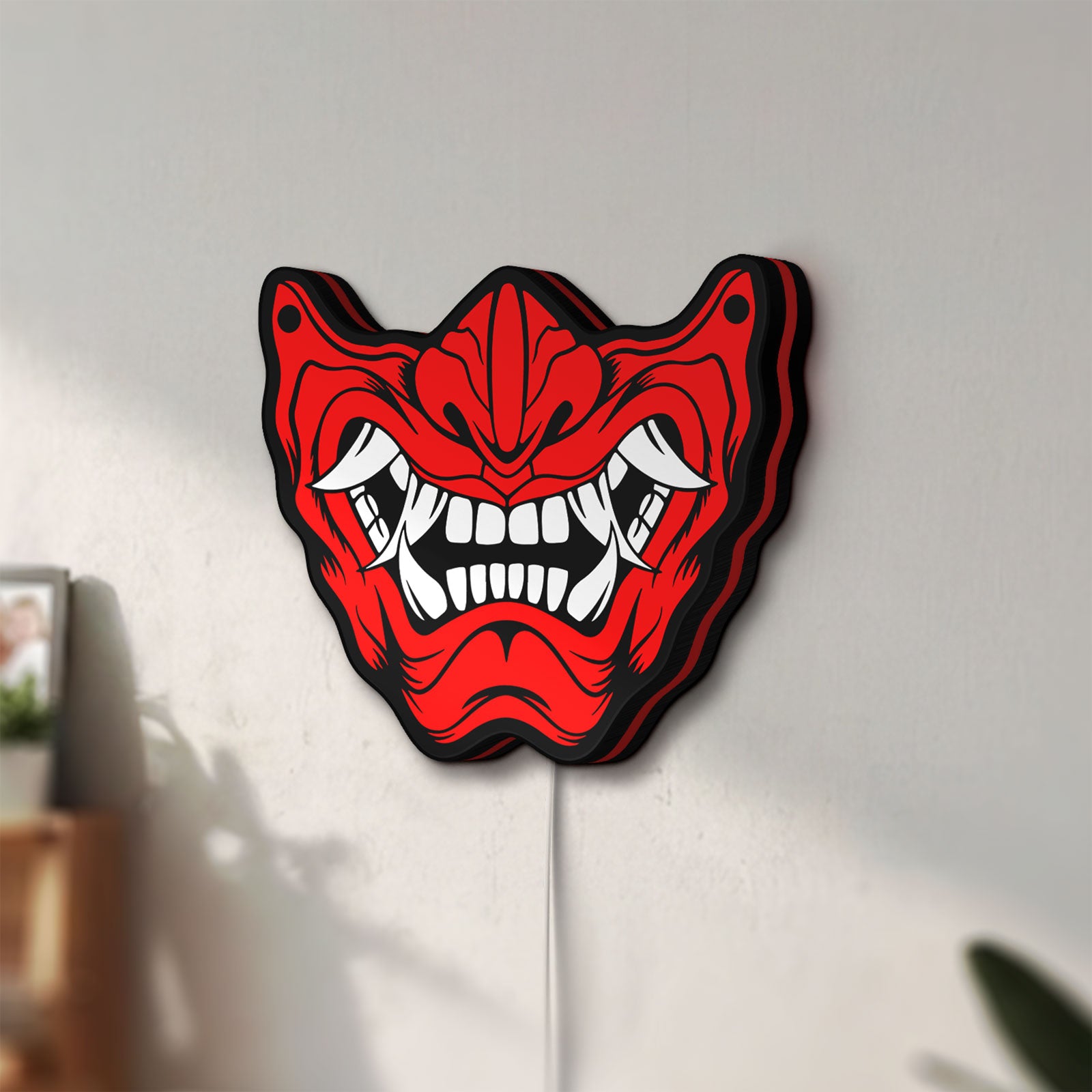 Unlit Oni Mas LED lightbox mounted on a wall in daylight