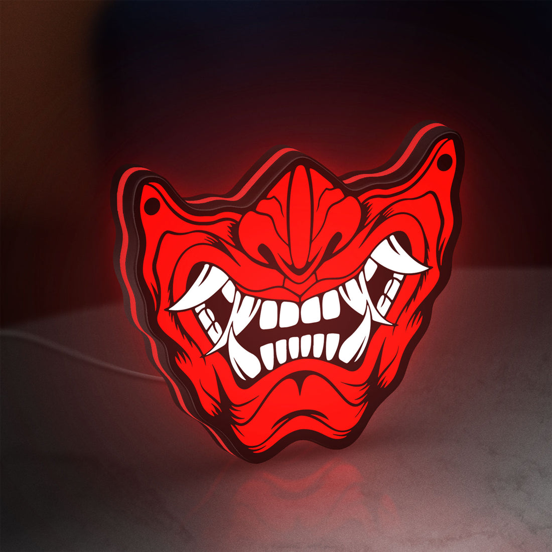 Oni Mas LED lightbox hanging on a wall with red glow
