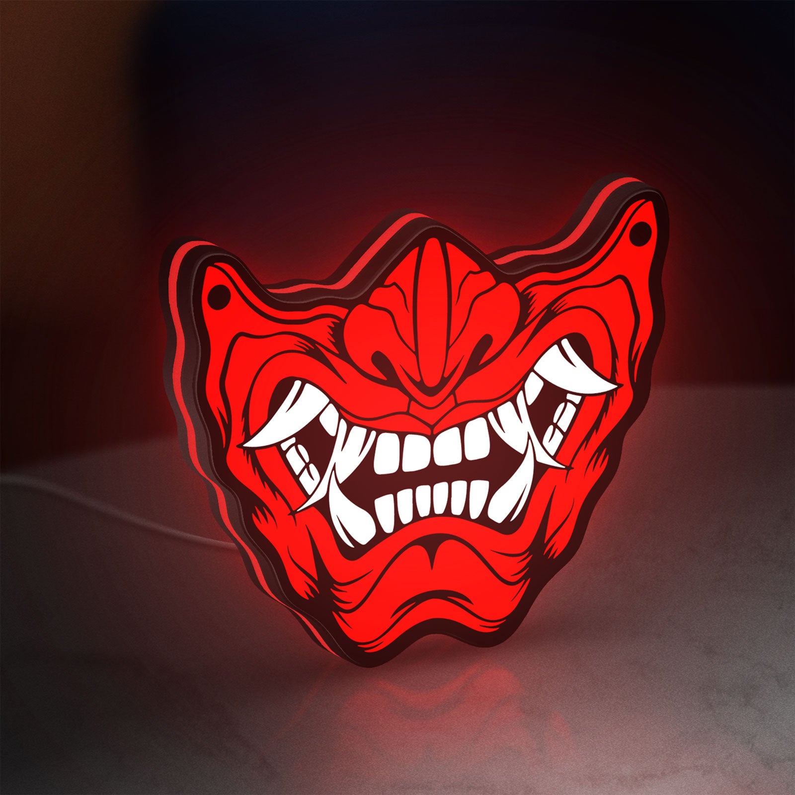 Oni Mas LED lightbox standing on a desk from an angled side view with red glow