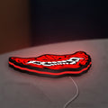 Oni Mas LED lightbox lying flat on a desk with red glow