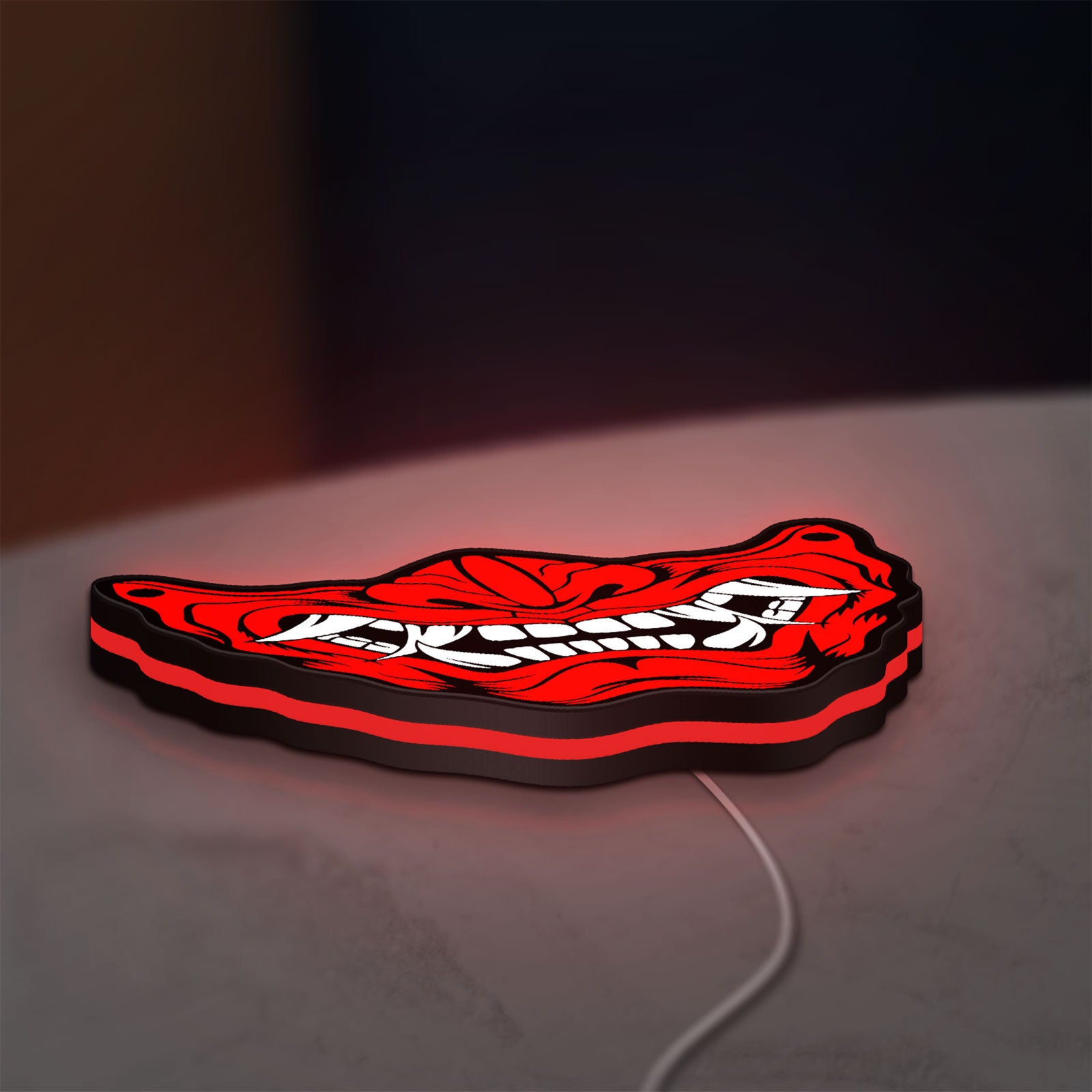 Oni Mas LED lightbox lying flat on a desk with red glow