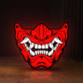 Front view of Oni Mas LED lightbox sign glowing on a wooden desk