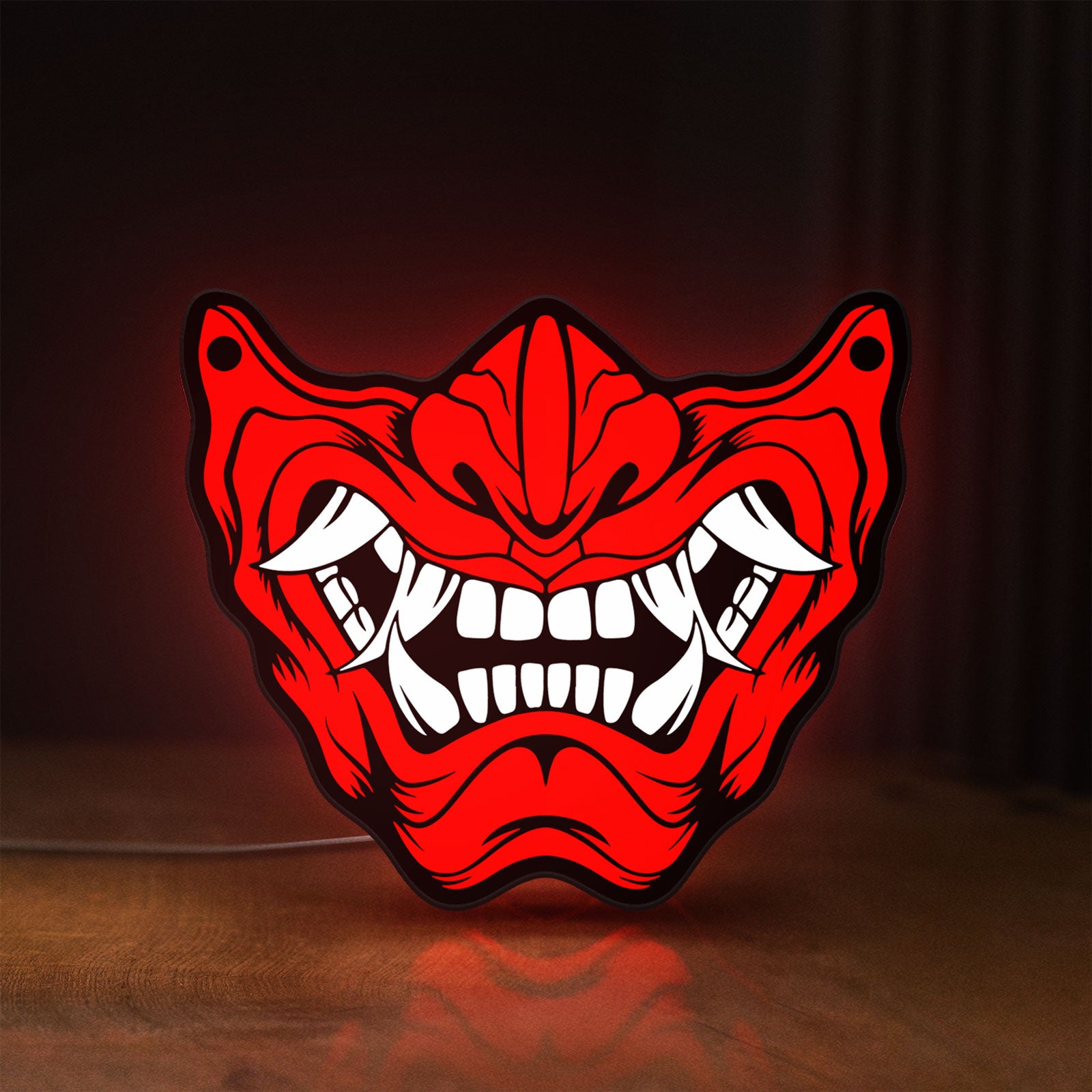 Front view of Oni Mas LED lightbox sign glowing on a wooden desk