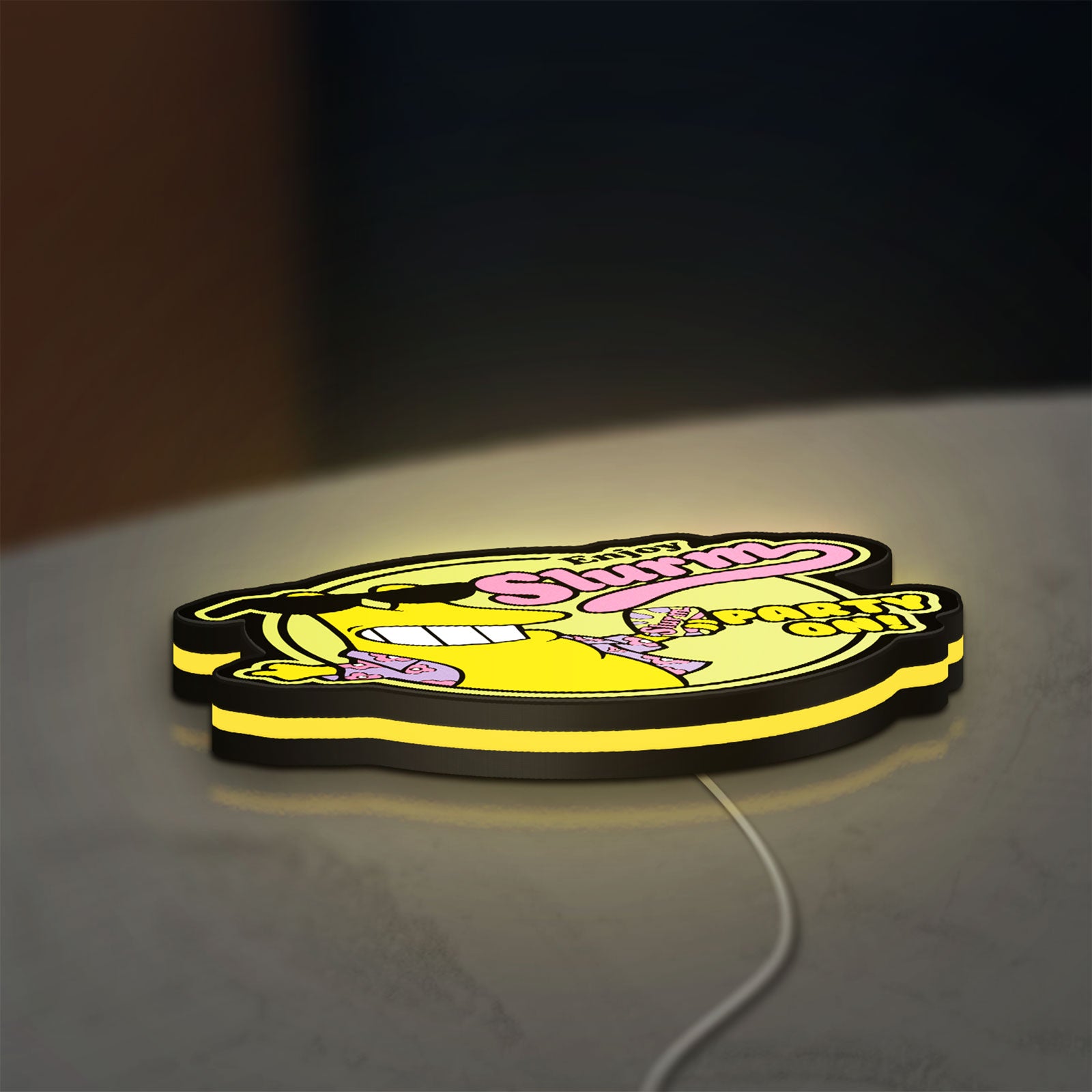 Futurama Slurm Cola Sci-Fi Comedy LED lightbox lying flat on a desk with yellow glow