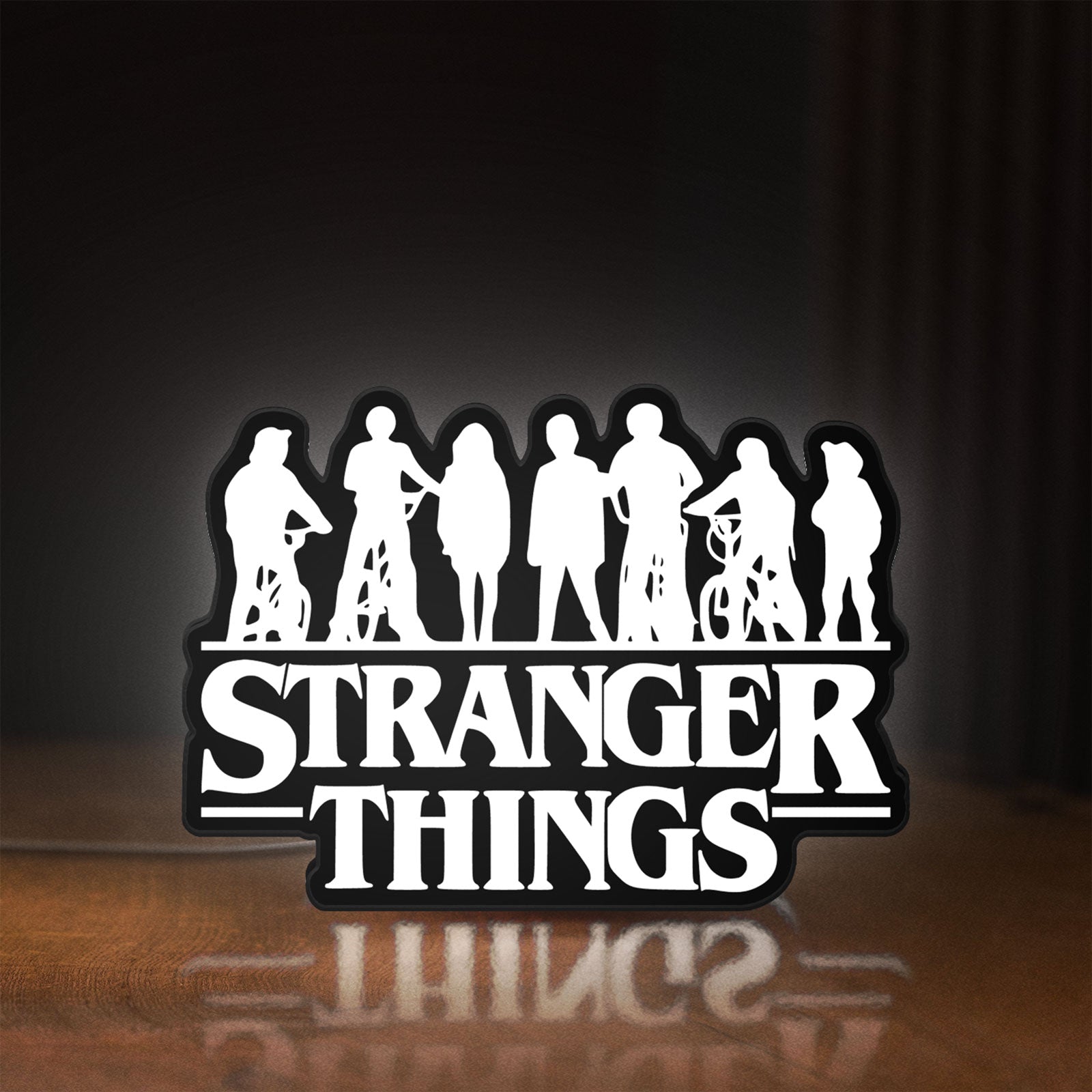 Front view of Stranger Things Logo The Upside Down LED lightbox sign glowing on a wooden desk