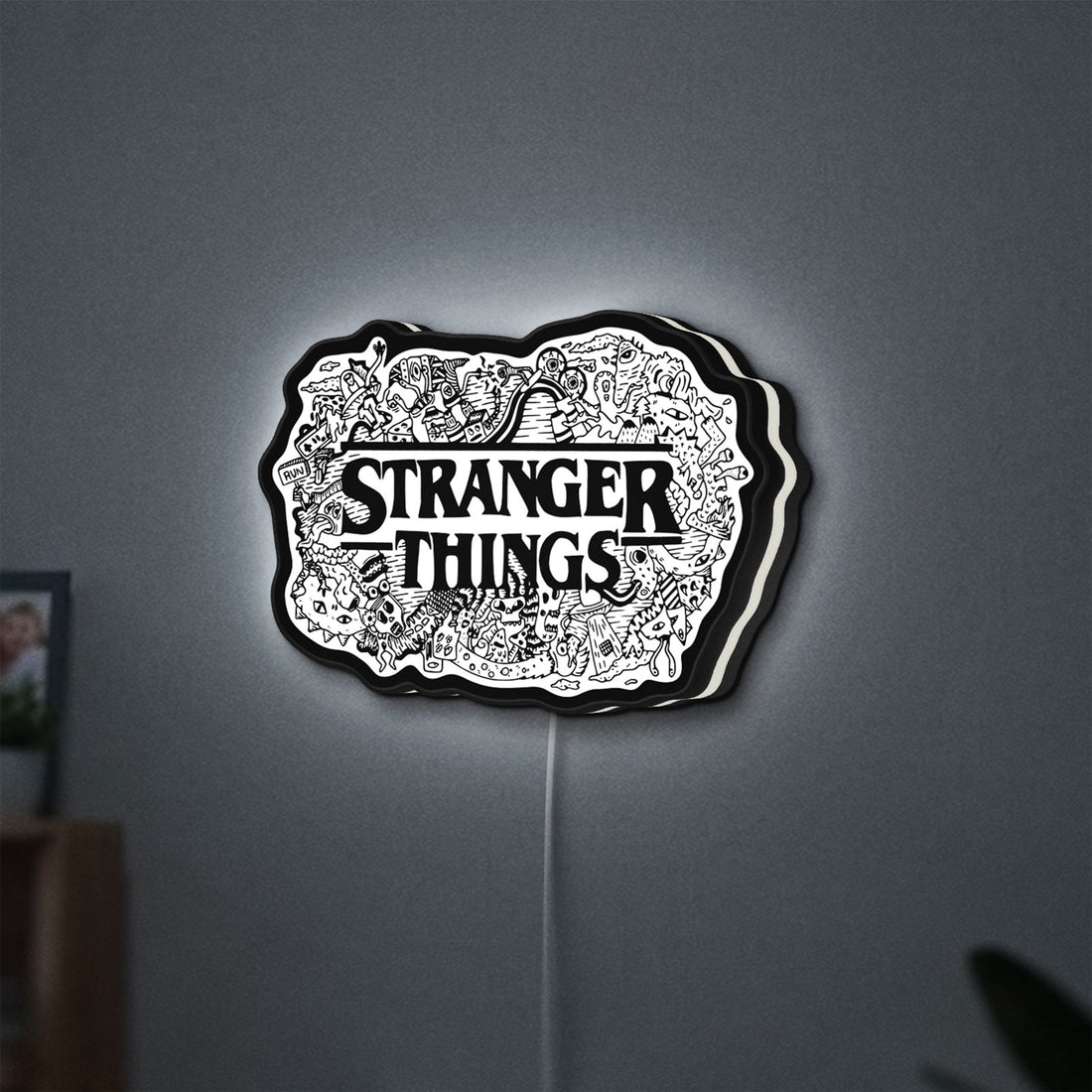 Stranger Things Logo The Upside Down LED lightbox hanging on a wall with white glow
