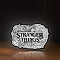 Front view of Stranger Things Logo The Upside Down LED lightbox sign glowing on a wooden desk