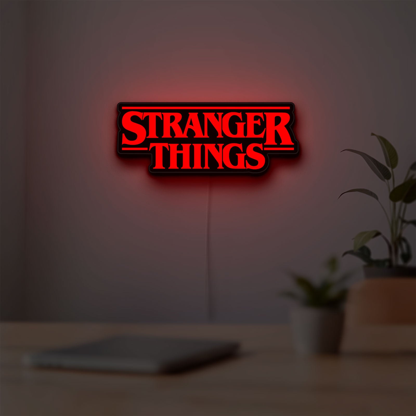 Stranger Things Logo The Upside Down LED lightbox hanging on a room wall with soft red light